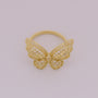 Gold butterfly ring on a light gray background