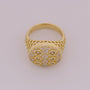 Gold ring with intricate design on a light gray background