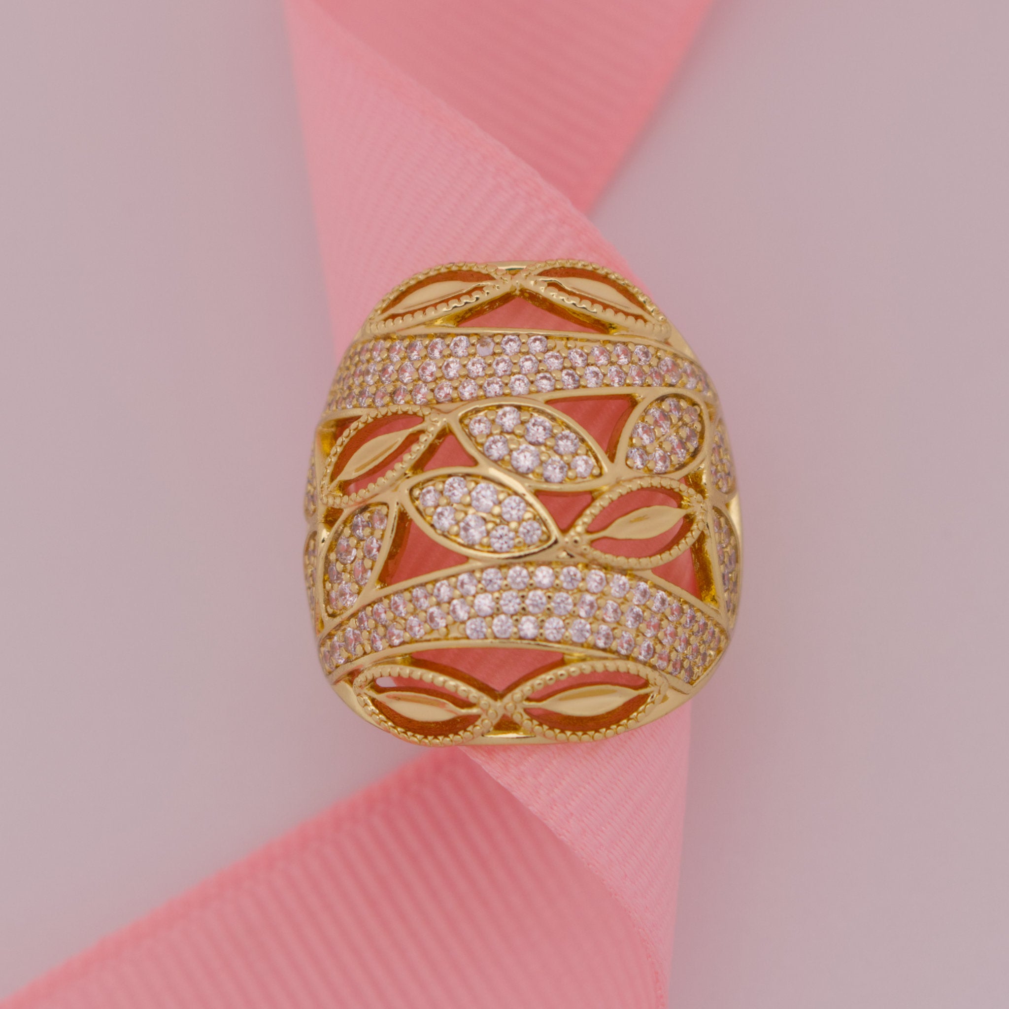 Gold ring with diamond accents on a pink ribbon