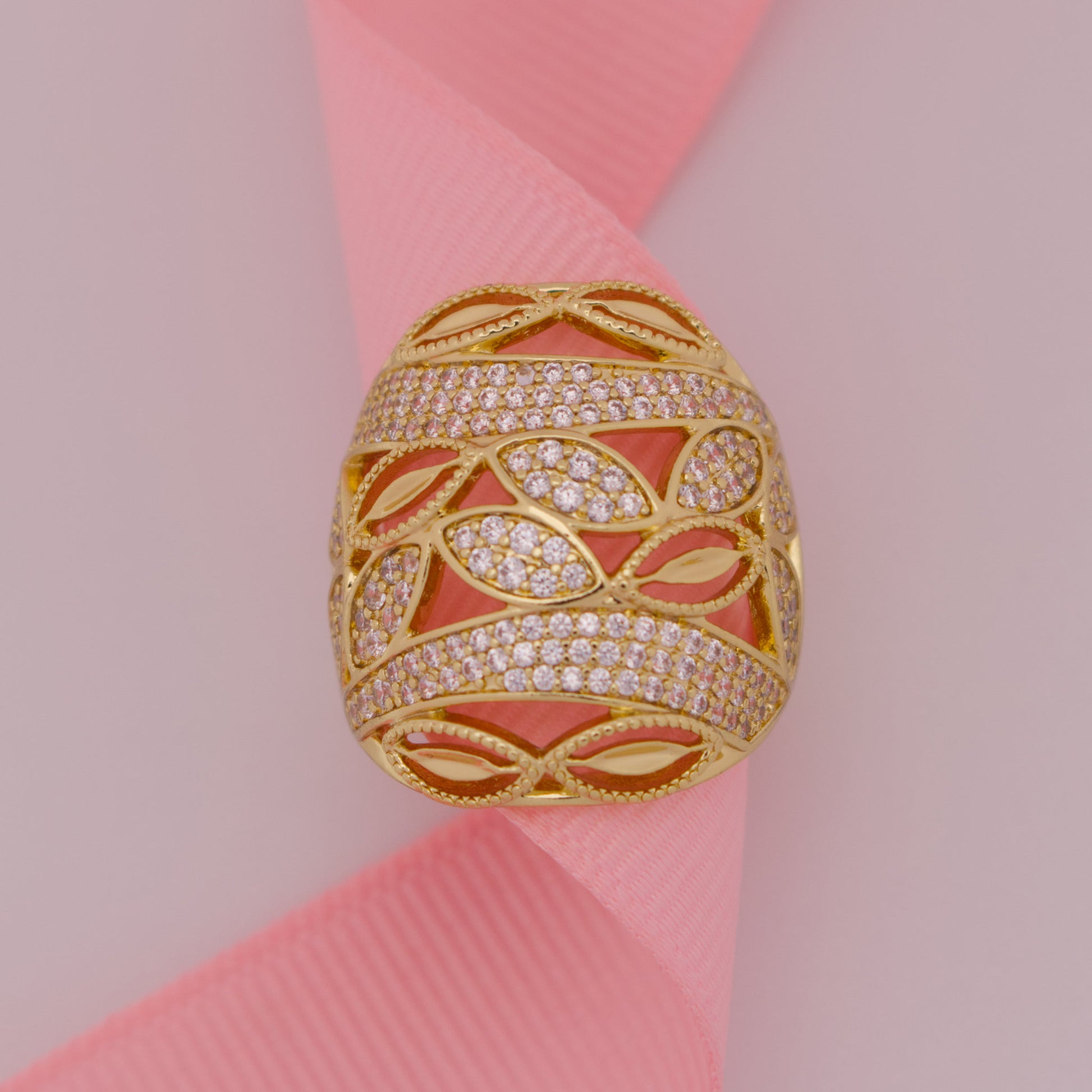 Gold ring with diamond accents on a pink ribbon
