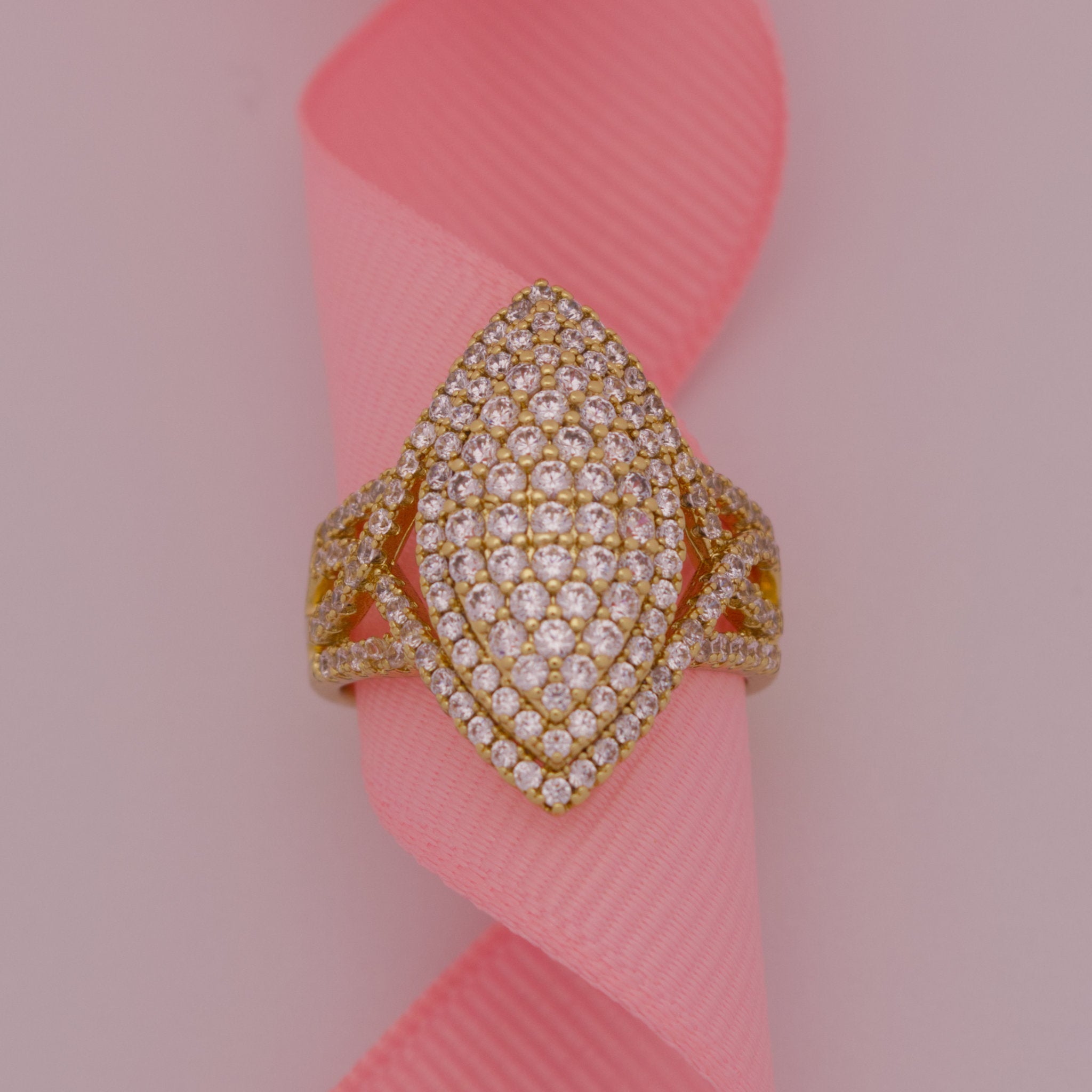Gold and diamond ring on a pink ribbon