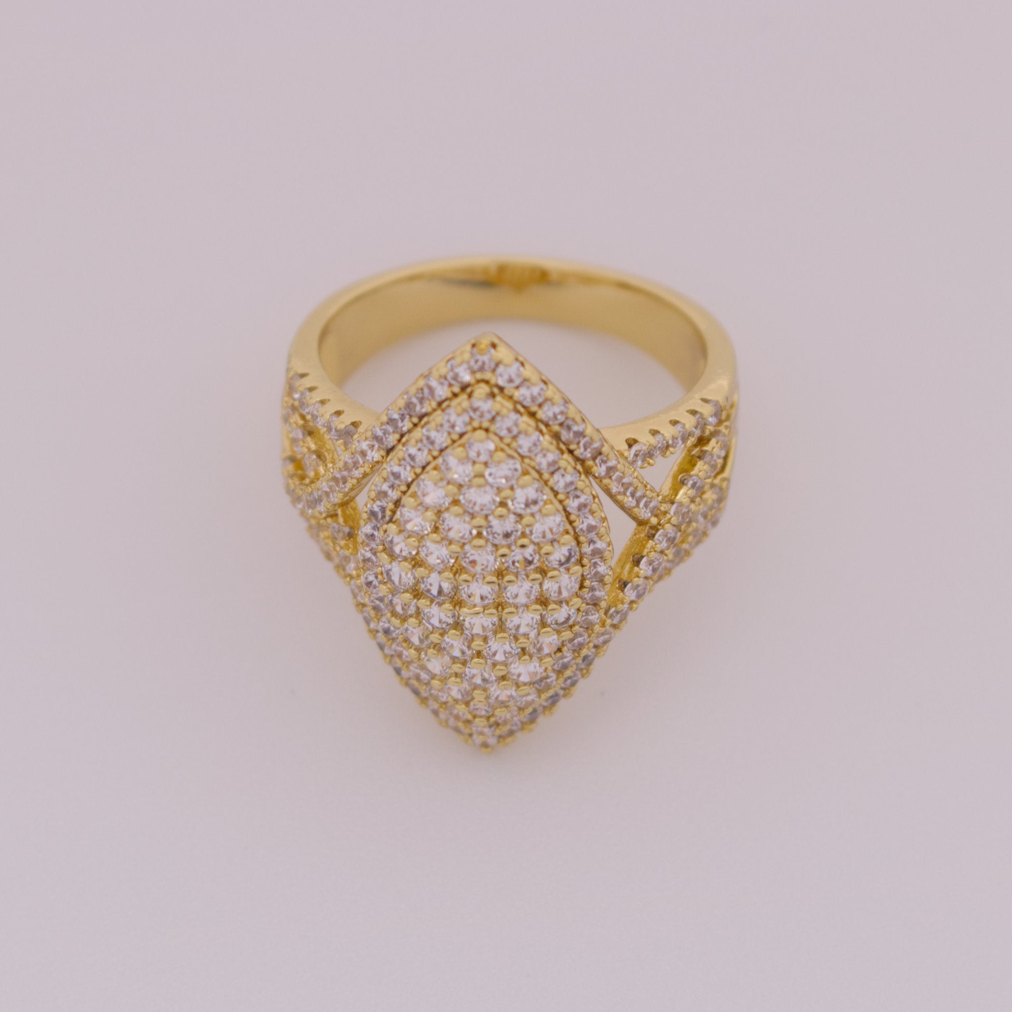 Gold ring with diamond accents on a light gray background