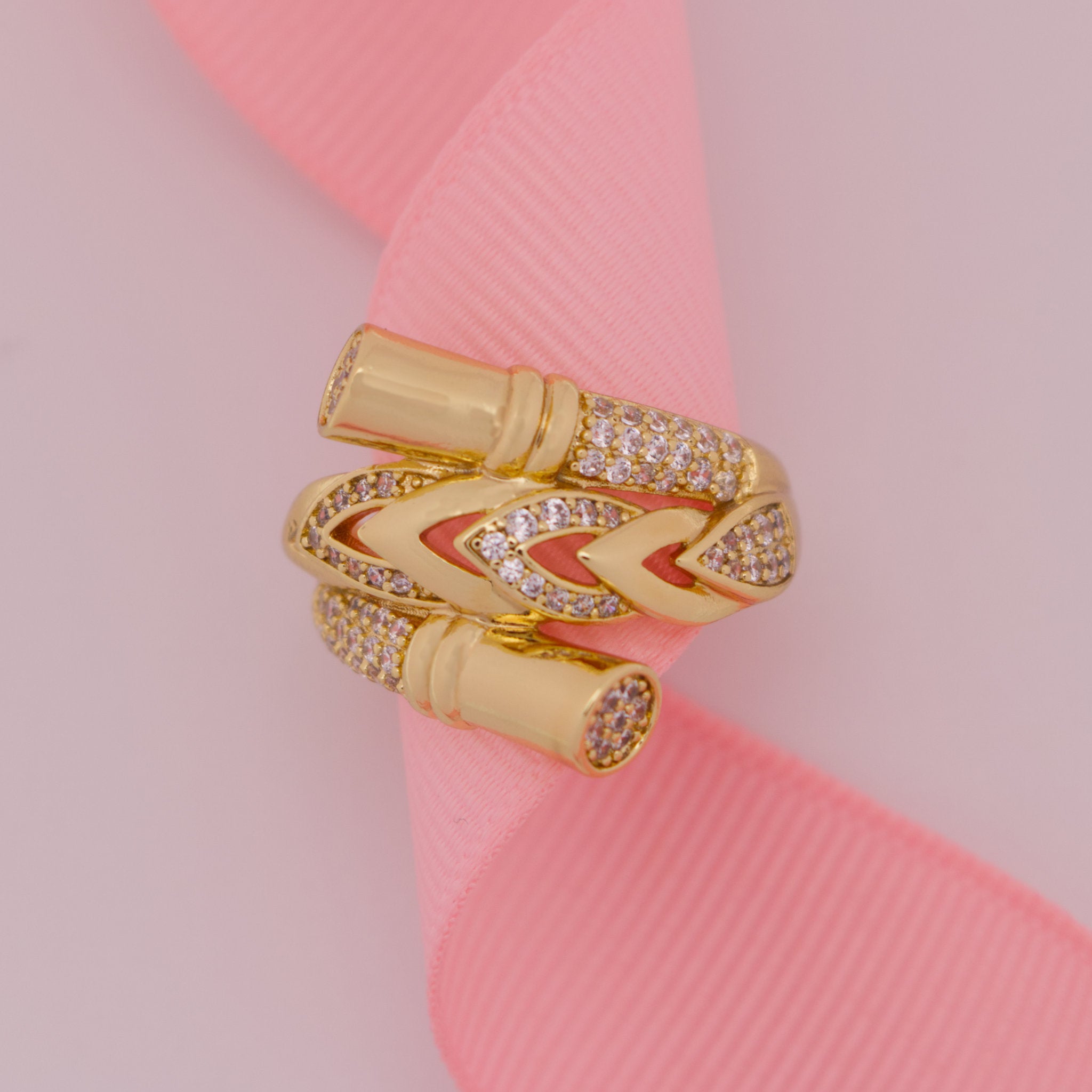 Gold ring with diamond accents on a pink ribbon