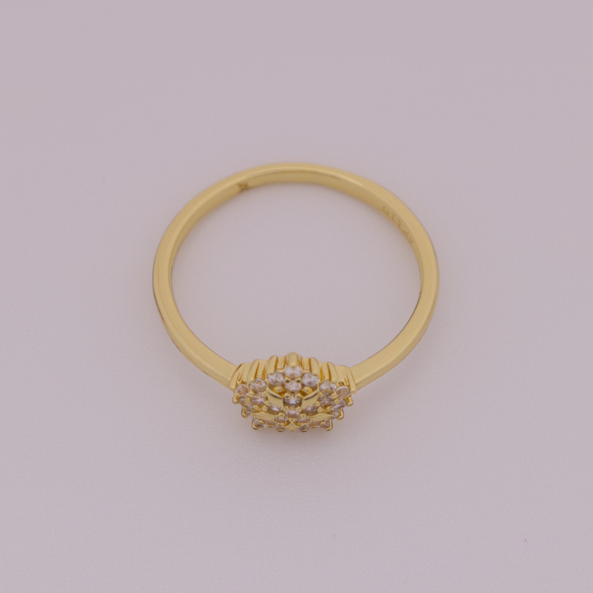 Gold ring with a decorative design on a light gray background