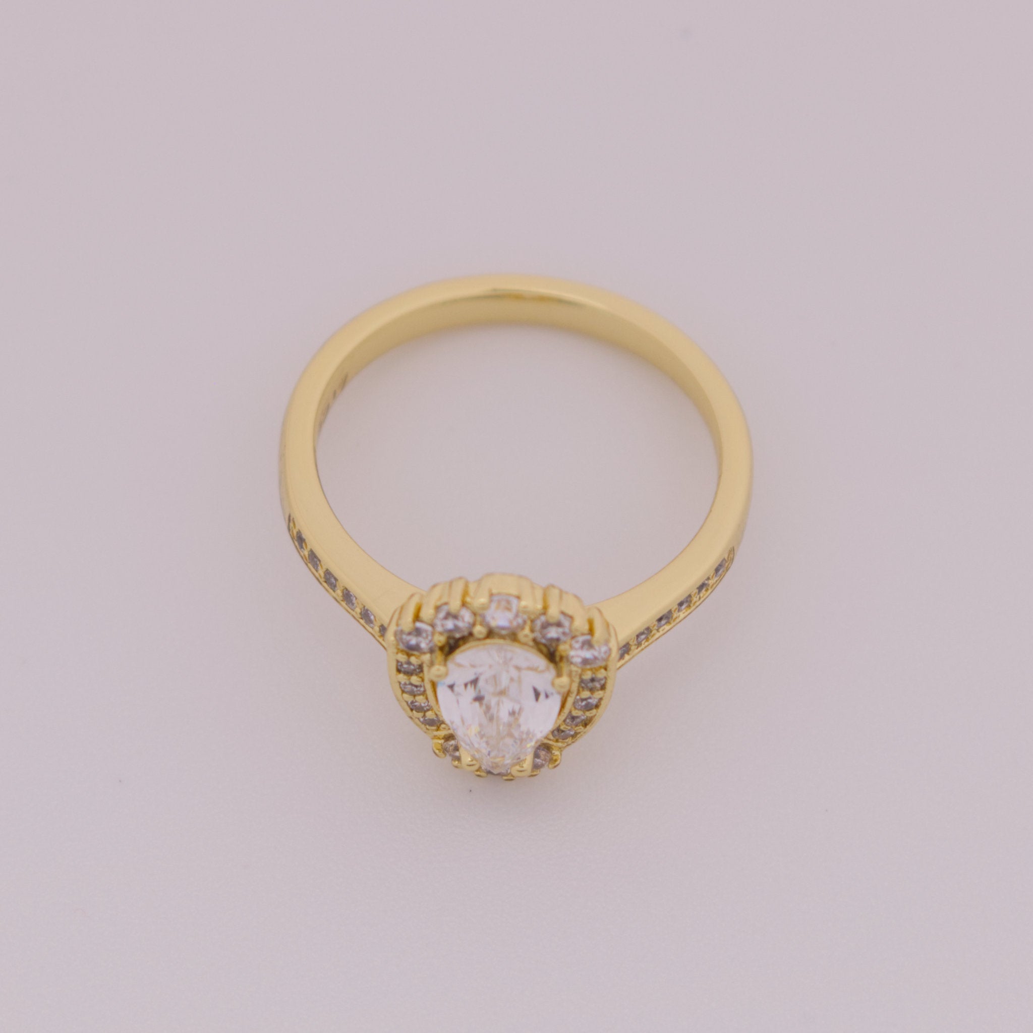 Gold ring with a diamond on a light gray background