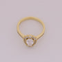 Gold ring with a diamond on a light gray background