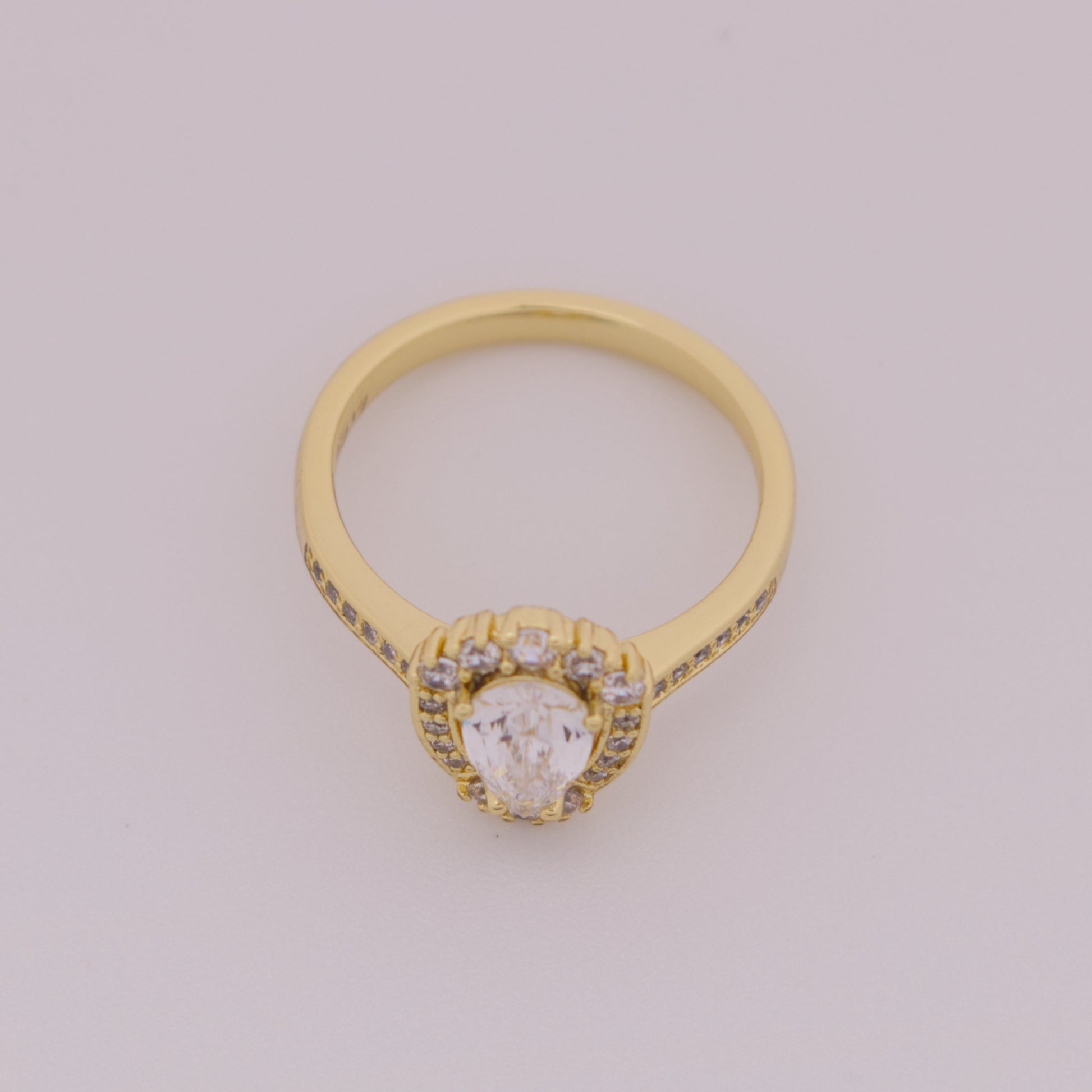 Gold ring with a diamond on a light gray background
