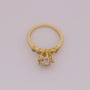 Gold ring with diamond-like stones on a light gray background
