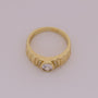 Gold ring with a diamond on a light gray background