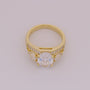 Gold ring with a central gemstone and smaller stones on a light gray background