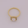 Gold ring with a diamond on a light gray background