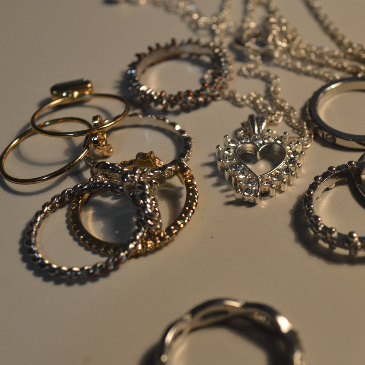Collection of gold and silver jewelry on a reflective surface