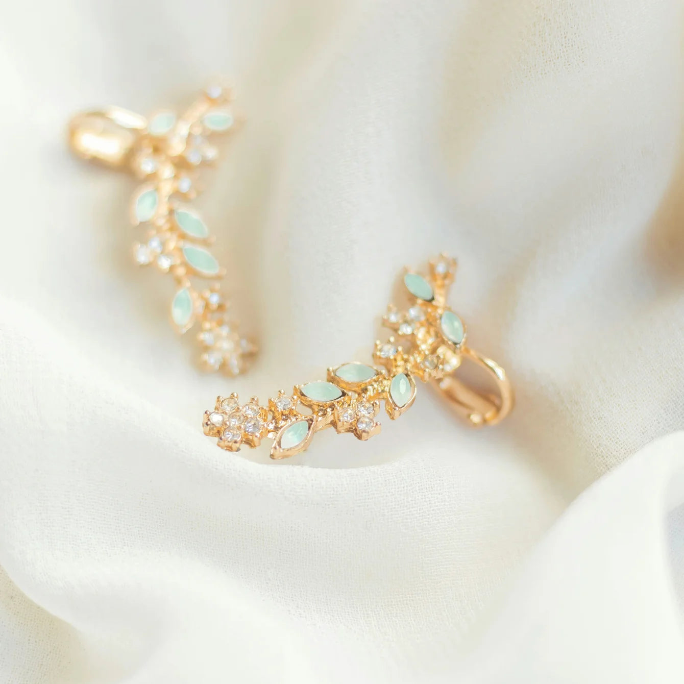 Gold and turquoise earring set on a soft white background