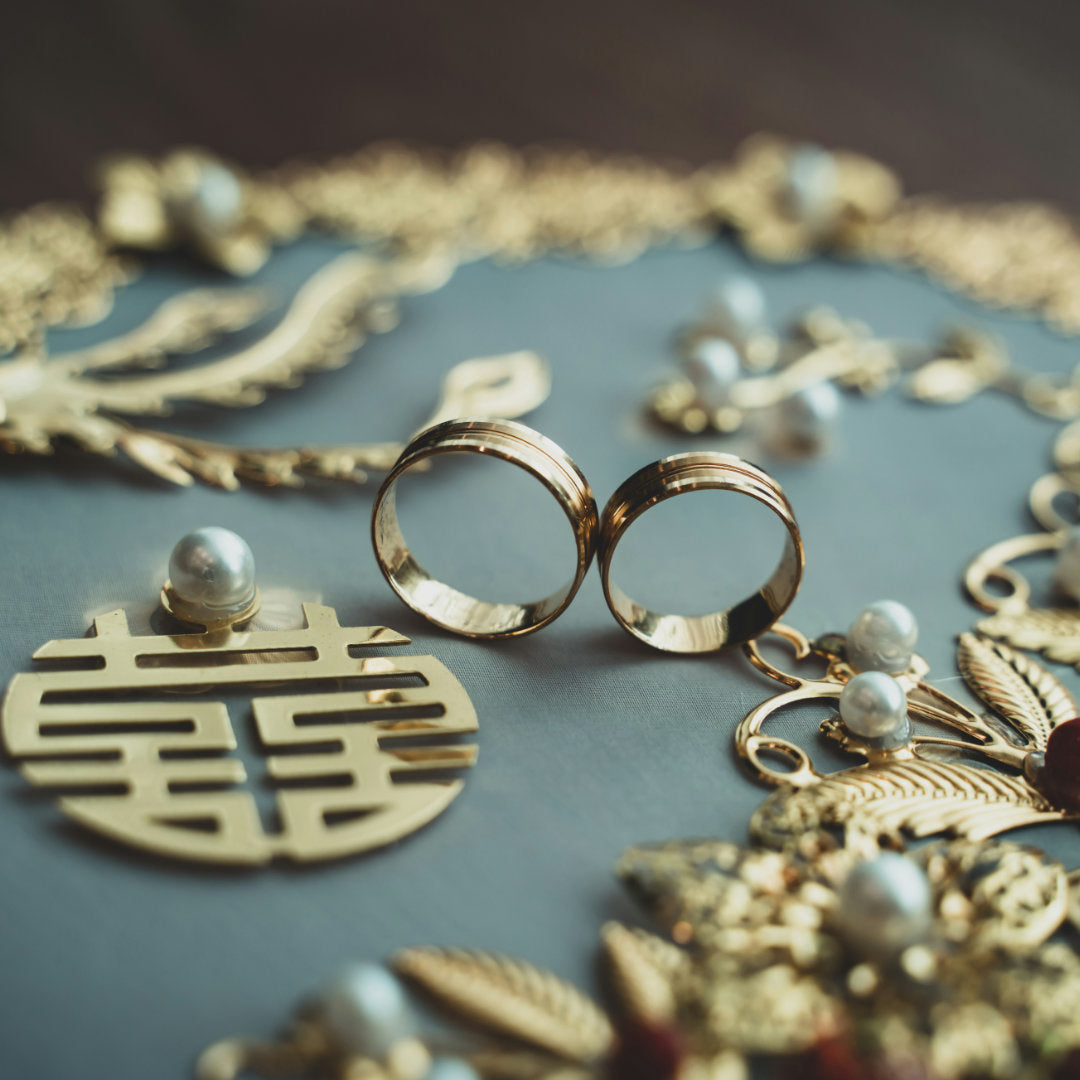 Gold jewelry with rings and pendants on a textured surface