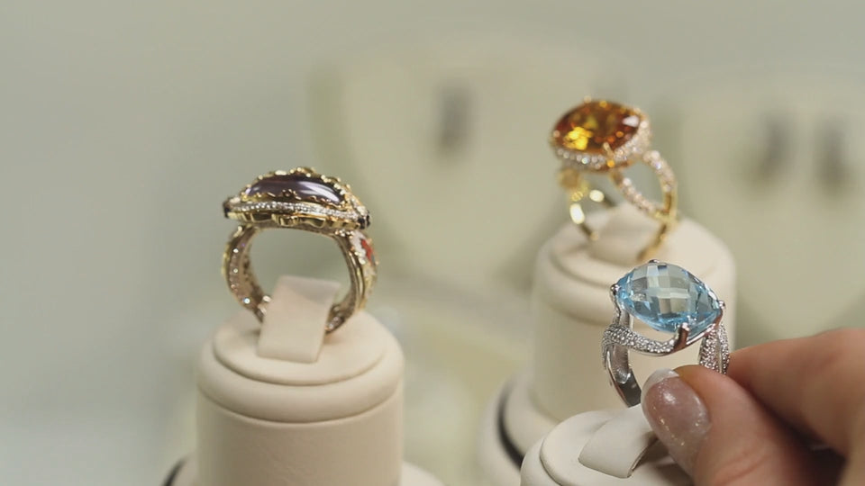 Hand showcasing a gold ring with a round stone in natural light