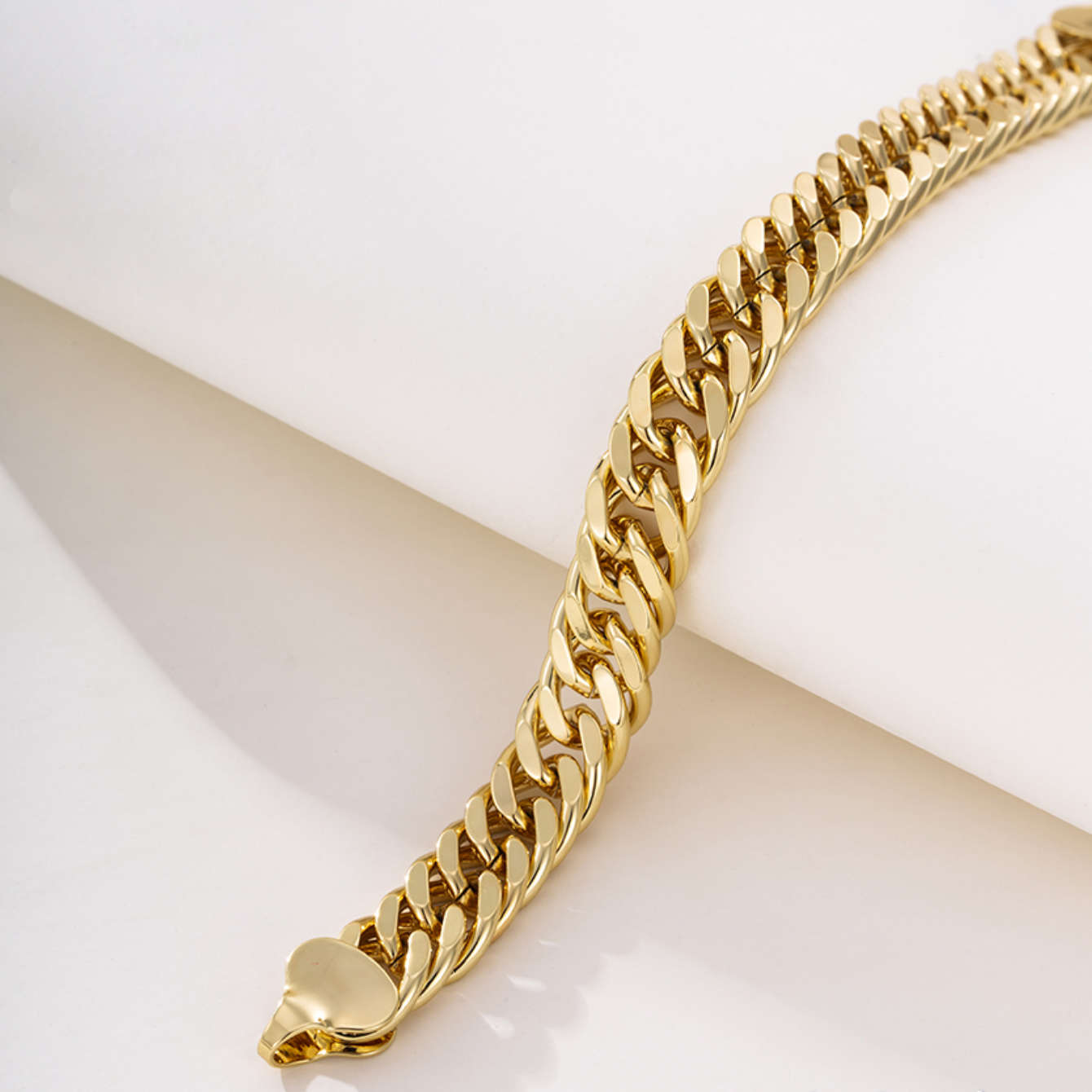 Gold chain bracelet on a light background